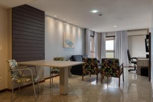 a living room with a table and chairs at Quality Suites Vila Velha in Vila Velha
