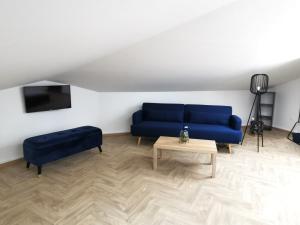 ein Wohnzimmer mit einem blauen Sofa und einem Tisch in der Unterkunft Logement - Nuit tendance centre ville de Mâcon E in Mâcon