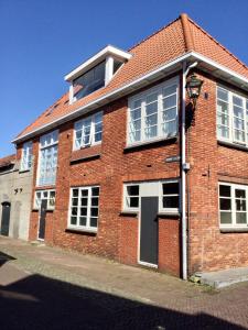 a red brick building with white windows on a street at Pension Montmaertre in Zierikzee