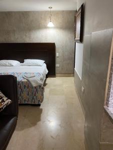 um quarto com uma cama e um sofá em Apartaestudio amplio em Barranquilla