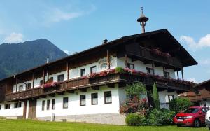 un bâtiment avec des fleurs sur son côté dans l'établissement Neubauhof, à Reith im Alpbachtal