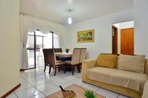 een woonkamer met een bank en een tafel bij Apto a beira mar com churrasq privativa em Itapema in Meia Praia