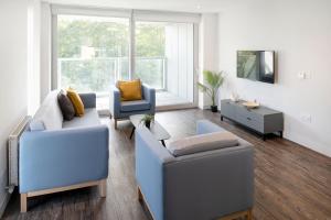 sala de estar con 2 sillas azules y mesa en Yugo Explore - Amnis House, en Cork
