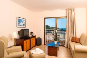 Una sala de estar con un sofá y un televisor. en Apartamentos Guitart, en Lloret de Mar
