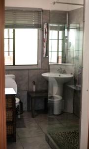 uma casa de banho com um lavatório, um WC e um espelho. em Manna Self Catering Guesthouse em Graskop