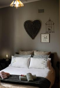 a bedroom with a large bed with a heart on the wall at Manna Self Catering Guesthouse in Graskop