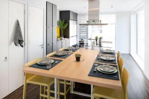 Yugo Explore - Amnis House في كورك: مطبخ بطاولة خشبية وكراسي صفراء