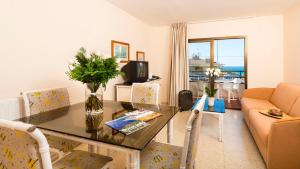 a living room with a table and a couch at Apartamentos Guitart in Lloret de Mar