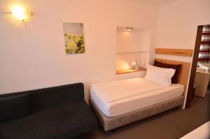 a small room with a bed and a couch at Landhotel Hohmann in Hilders