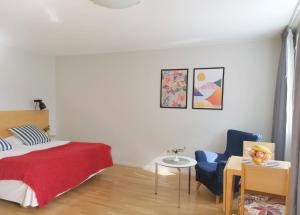 a bedroom with a bed, chair, desk and a lamp at 2Home Hotel Apartments in Solna