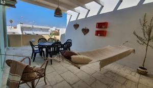 a hammock on a patio with a table and chairs at MataRoom in Torre Lapillo