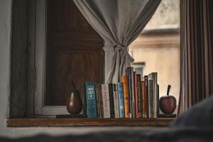 a book shelf with books and apples on it at B19 Kuldiga in Kuldīga