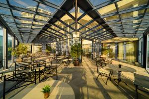 an office building with tables and chairs and windows at Azalia Beach Hotel Balneo & SPA in St. St. Constantine and Helena