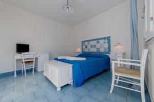 a bedroom with a bed and a desk and a tv at Tenuta De Marco in Presicce