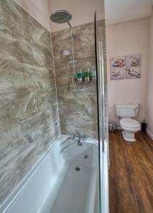 a bathroom with a bath tub and a toilet at Tallentire Hall in Cockermouth
