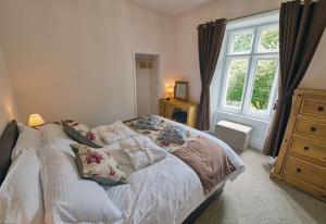 a bedroom with a bed with pillows and a window at Tallentire Hall in Cockermouth