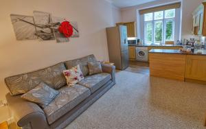 a living room with a couch and a kitchen at Tallentire Hall in Cockermouth
