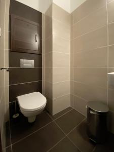 a bathroom with a toilet and a trash can at No.1 Apartment House Oliver in Štrbské Pleso