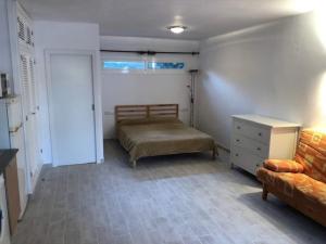 een slaapkamer met een bed, een dressoir en een bank bij Binisafua Playa - Bungalow 14 in Binisafua