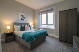 a bedroom with a large bed and a window at Townend Apartment in Dumbarton