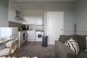 a living room with a couch and a kitchen at Townend Apartment in Dumbarton