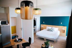a bedroom with a bed and a table and a dining room at Hôtel Café Miramar in Le Grau-du-Roi