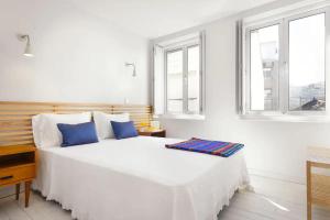 - une chambre blanche avec un grand lit et des oreillers bleus dans l'établissement O´Porto Outeiro Flat, à Porto