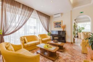 uma sala de estar com mobiliário amarelo e uma lareira em Hotel Arcade em Rimini