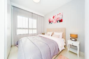 - une chambre blanche avec un grand lit et une fenêtre dans l'établissement Luxurious 2 Bedroom Apartment near the beach, à La Horadada