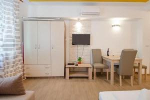 ein Wohnzimmer mit einem Tisch und Stühlen sowie einem Schrank in der Unterkunft Guest House Mia in Split