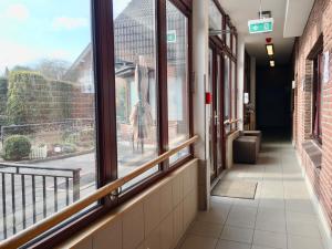 a hallway of a building with windows and a person standing outside at Hana Aparthotel in Hamburg