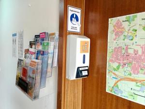 a hotel room door with an ipod and a map at Hana Aparthotel in Hamburg