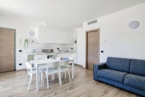 een woonkamer met een tafel en stoelen en een blauwe bank bij Silvia Ossuccio House - The House Of Travelers in Ossuccio