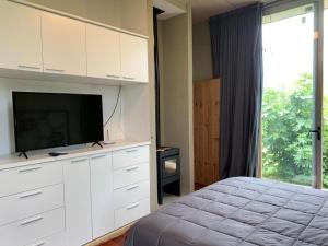 1 dormitorio con 1 cama y TV de pantalla plana en Magenta Complejo Cabañas & Spa en San Javier