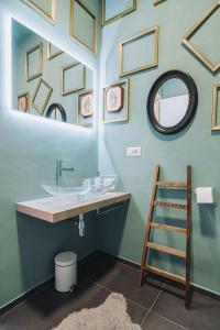 a bathroom with a sink and framed pictures on the wall at B&B CAVOUR 117 in Porto SantʼElpidio