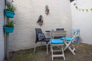 une table et des chaises sur une terrasse agrémentée de plantes dans l'établissement Oosterhouse, à Zandvoort
