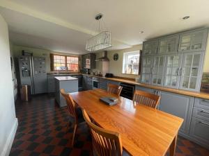 a large kitchen with a wooden table and chairs at Common Farmhouse in Newark-on-Trent