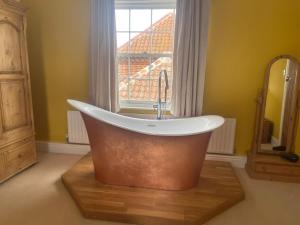 a bath tub in a bathroom with a window at Common Farmhouse in Newark-on-Trent +9 photos