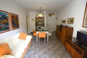 ein Wohnzimmer mit einem weißen Sofa und einem Tisch in der Unterkunft Lignano Pineta nice flat in Lignano Sabbiadoro