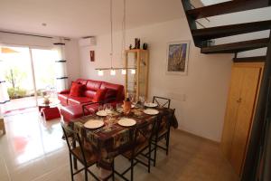 ミアミ・プラトーヤにあるCasa Chiquiのリビングルーム(テーブル、赤いソファ付)