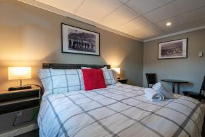 a bedroom with a large white bed with red pillows at The Cache Hotel and Lodgings in Golden