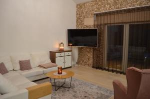 - un salon avec un canapé blanc et une télévision dans l'établissement Ravila Puhkemaja, à Kuressaare