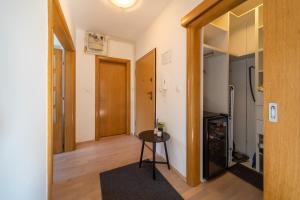 a hallway with a small table and a door at SUPER PetrovA Apartment in Zagreb