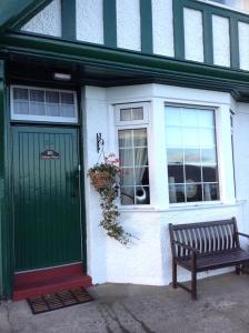 una puerta verde y un banco frente a una casa en Eilean View, en Lamlash