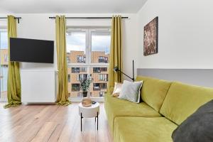 a living room with a green couch and a large window at Modern Apartments Wrocław Grabiszyn by Renters in Wrocław