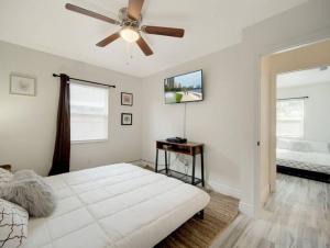 a white bedroom with a ceiling fan and a bed at Modern Bayshore Home 46 in Tampa