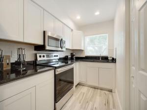 a kitchen with white cabinets and a stove top oven at Modern Bayshore Home 46 in Tampa