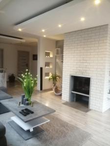 a living room with a white brick fireplace at Pokoje Gościnne U Bosmana in Dźwirzyno