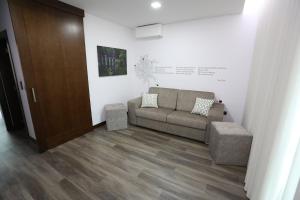 uma sala de estar com um sofá e uma parede em O Casario em Mirandela