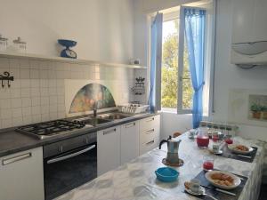 een keuken met een fornuis, een wastafel en een tafel bij Michela Apartment Sea View in Levanto